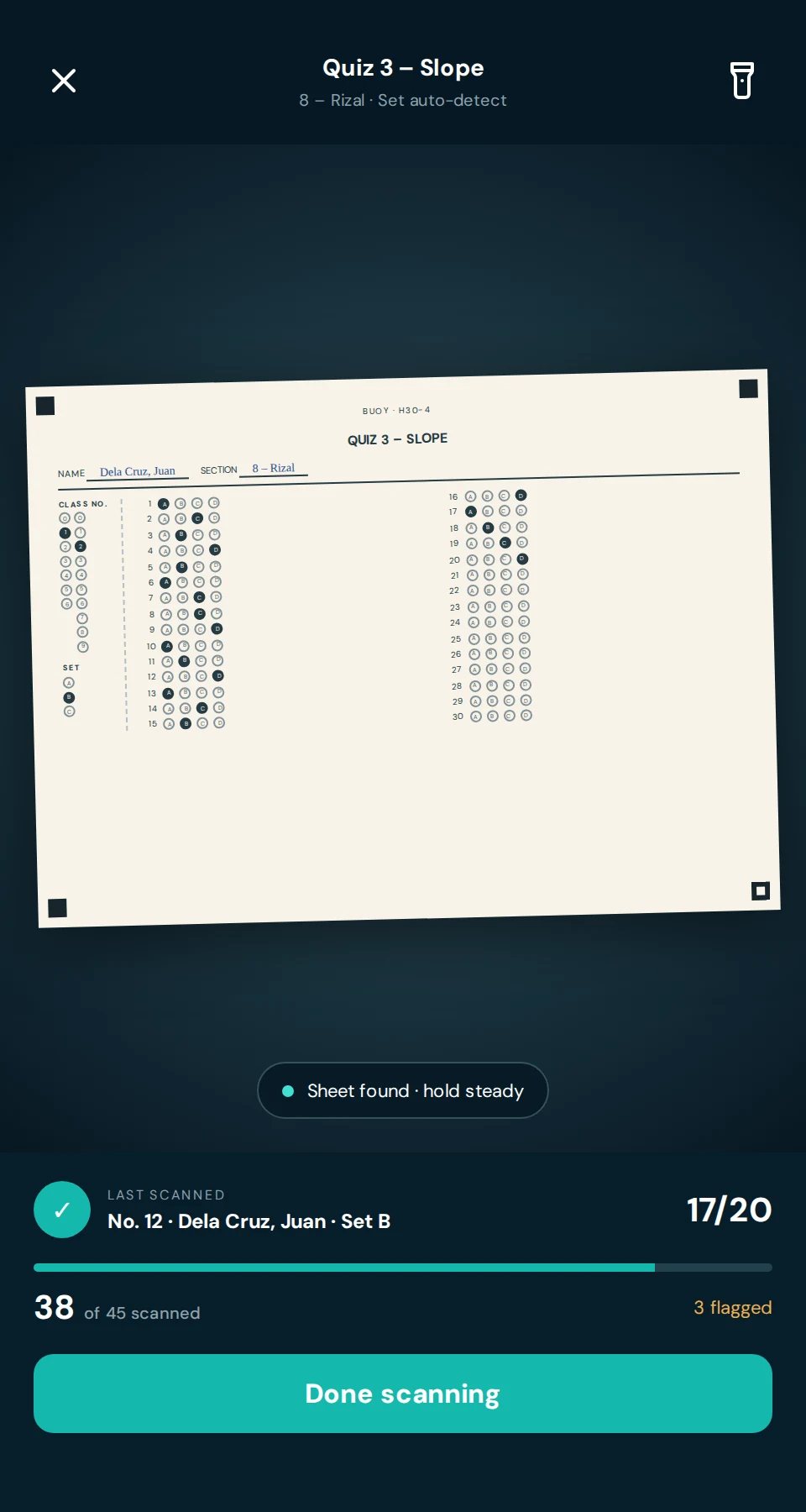 The scanner holding an answer sheet in view: the last paper scored 17 of 20, with 38 of 45 papers scanned and 3 flagged.